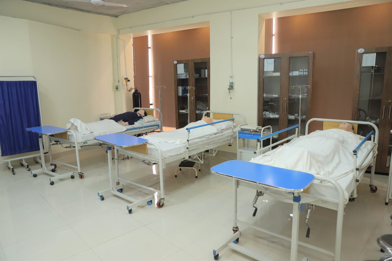 Campus facilities in KIHS: simulation lab with dummy patients on hospital beds for student practice.