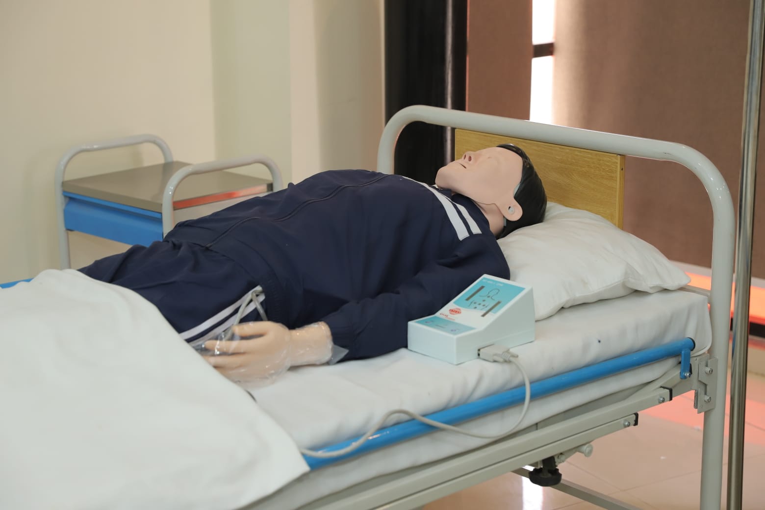 Campus facilities in KIHS: simulation lab with medical dummy on hospital bed for training
